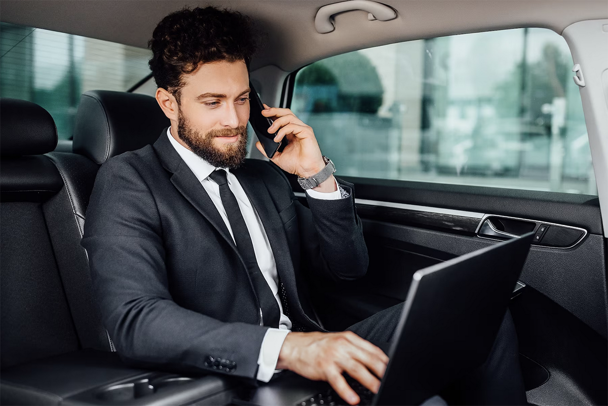 Man Working With His Laptop A Car